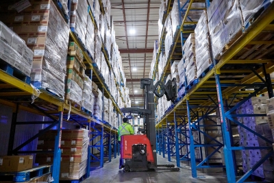 Démontage rapide dans un entrepôt frigorifique avec un chariot élévateur déplaçant des palettes de nourriture congelée à travers des étagères à haute hauteur pour réduire rapidement la température des produits.