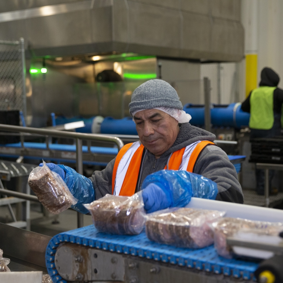 Worker processing food at a Lineage facility