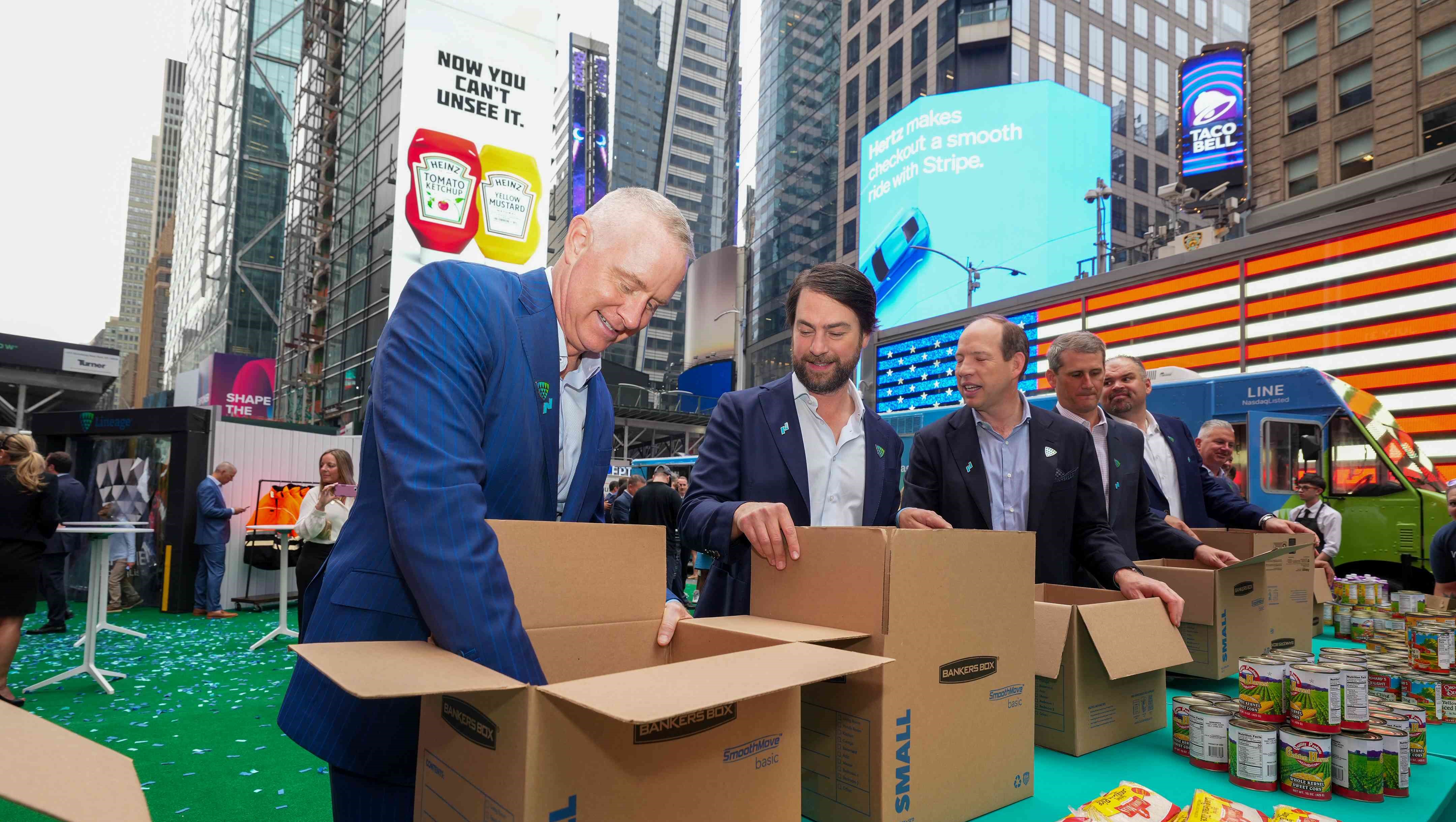 Greg Lehmkuhl , Consejero Delegado Lineage , y Adam Forste y Kevin Marchetti, cofundadores, se ofrecen voluntarios para empaquetar paquetes de comida en Times Square, Nueva York.