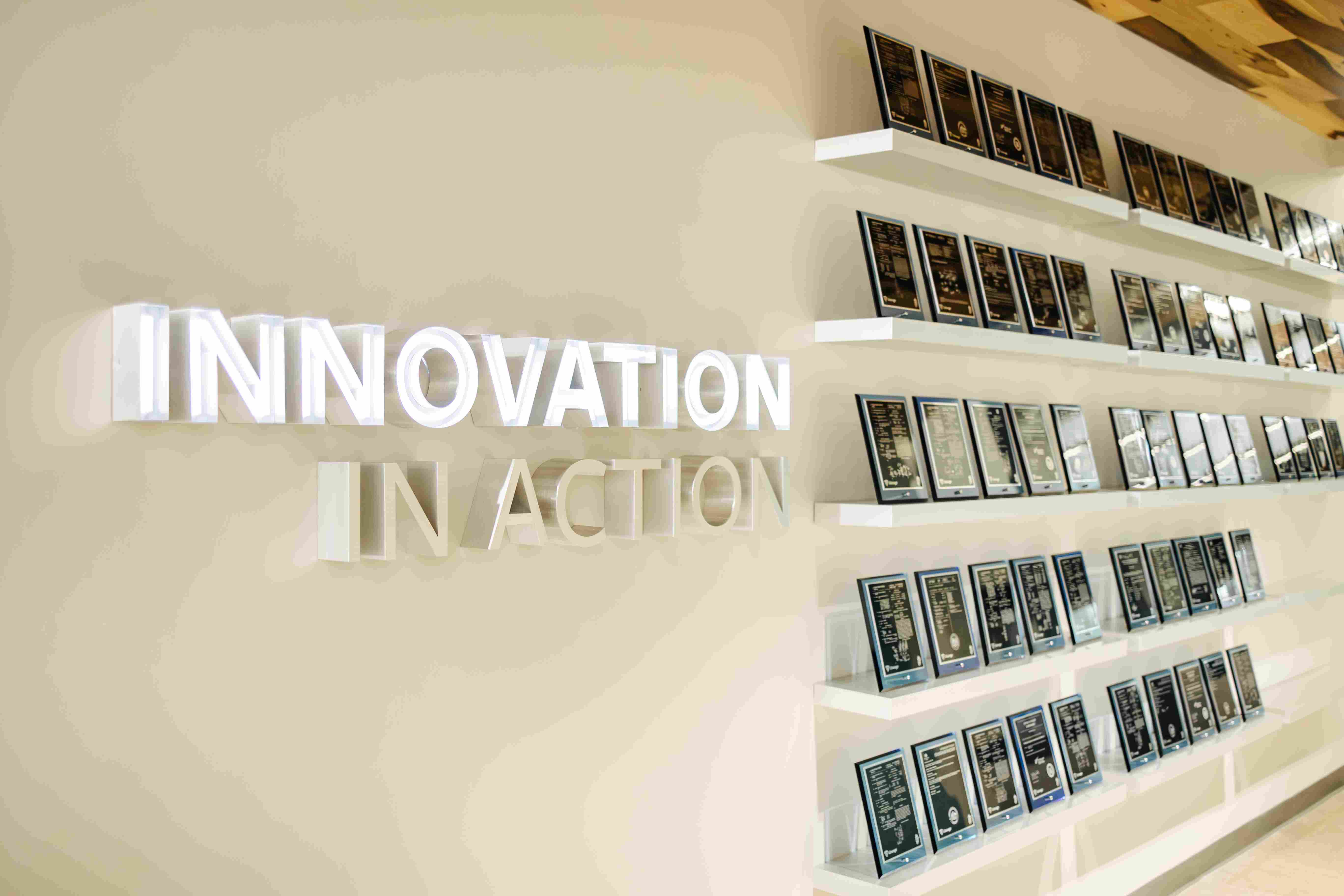 Una pared de la sede central de Lineage en Novi muestra placas de patentes concedidas en estanterías blancas junto a un cartel tridimensional que reza "Innovación en acción".