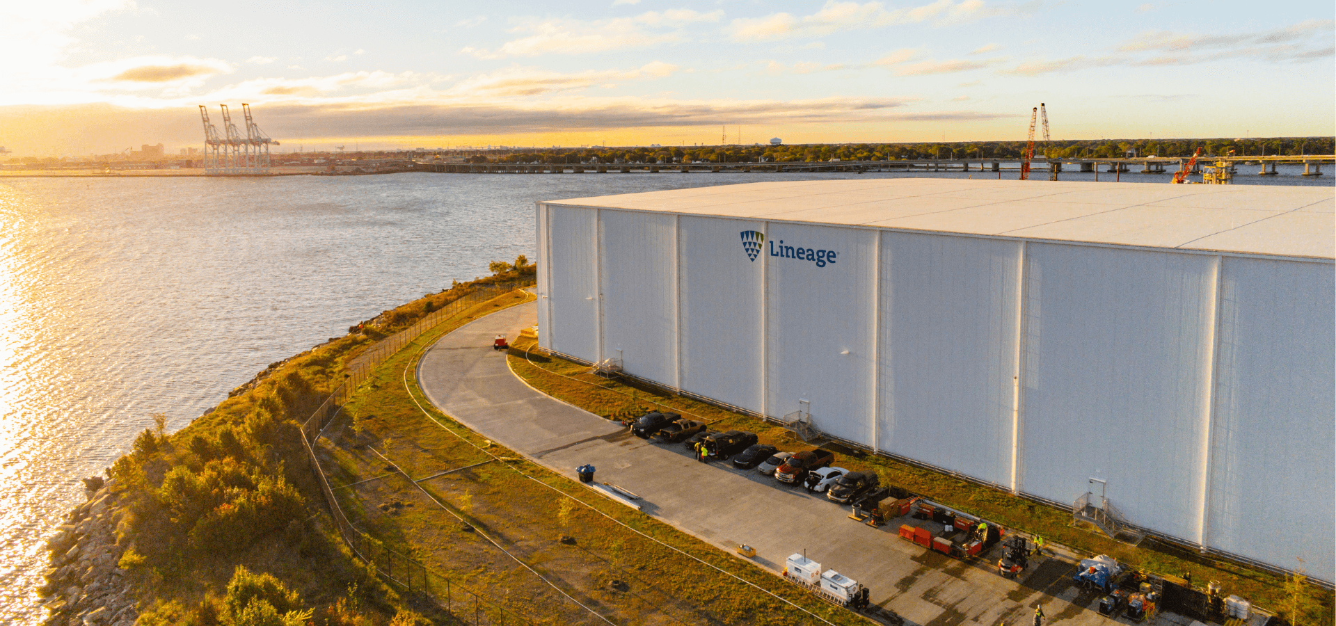 Las instalaciones de Lineage en Portsmouth, Virginia, situadas cerca del paseo marítimo, con una vista del puerto y varias grúas al fondo.