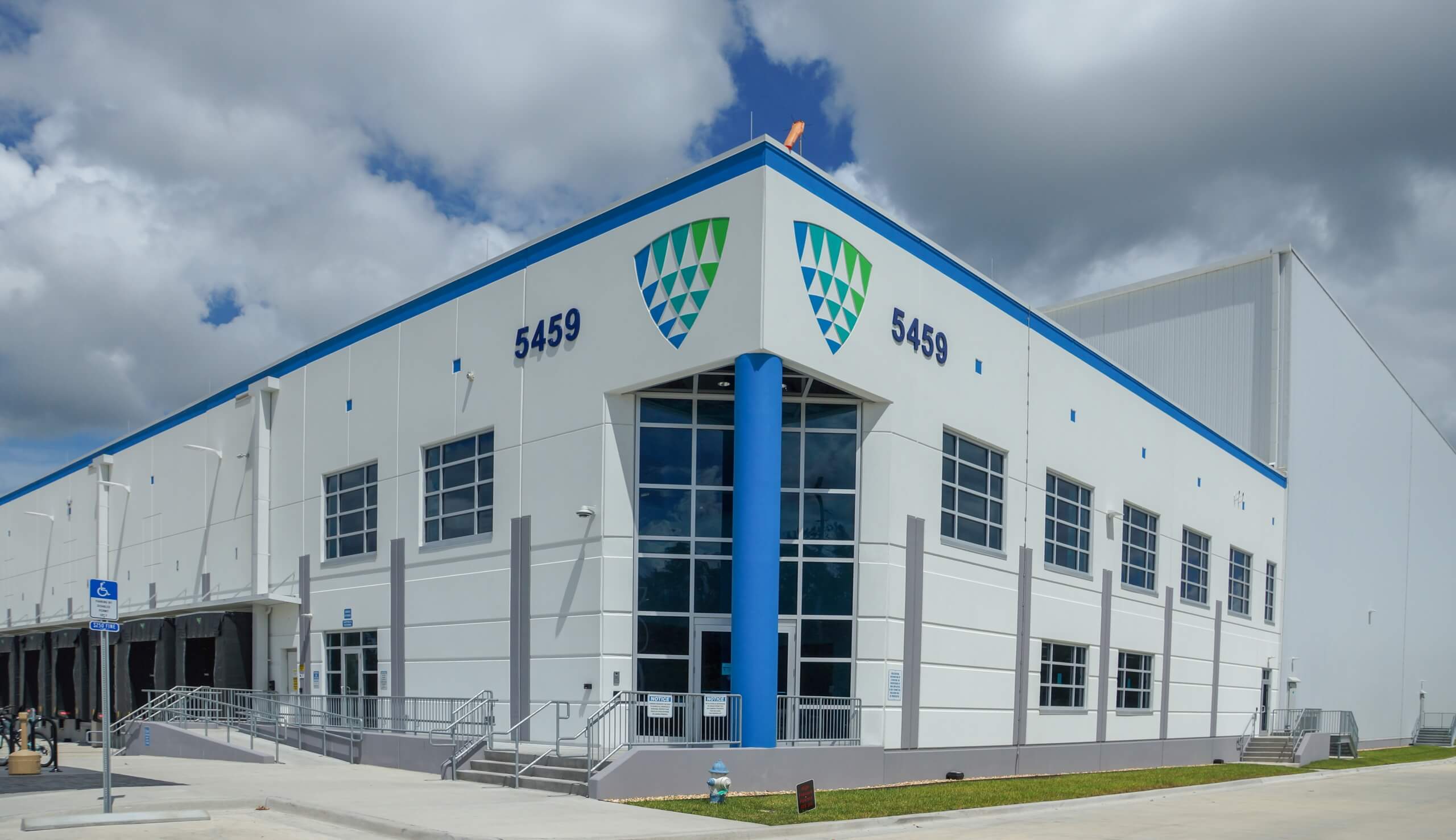 Vista exterior de las instalaciones de Lineageen Doolittle, Jacksonville, que muestra el moderno diseño del almacén frigorífico bajo un cielo nublado.