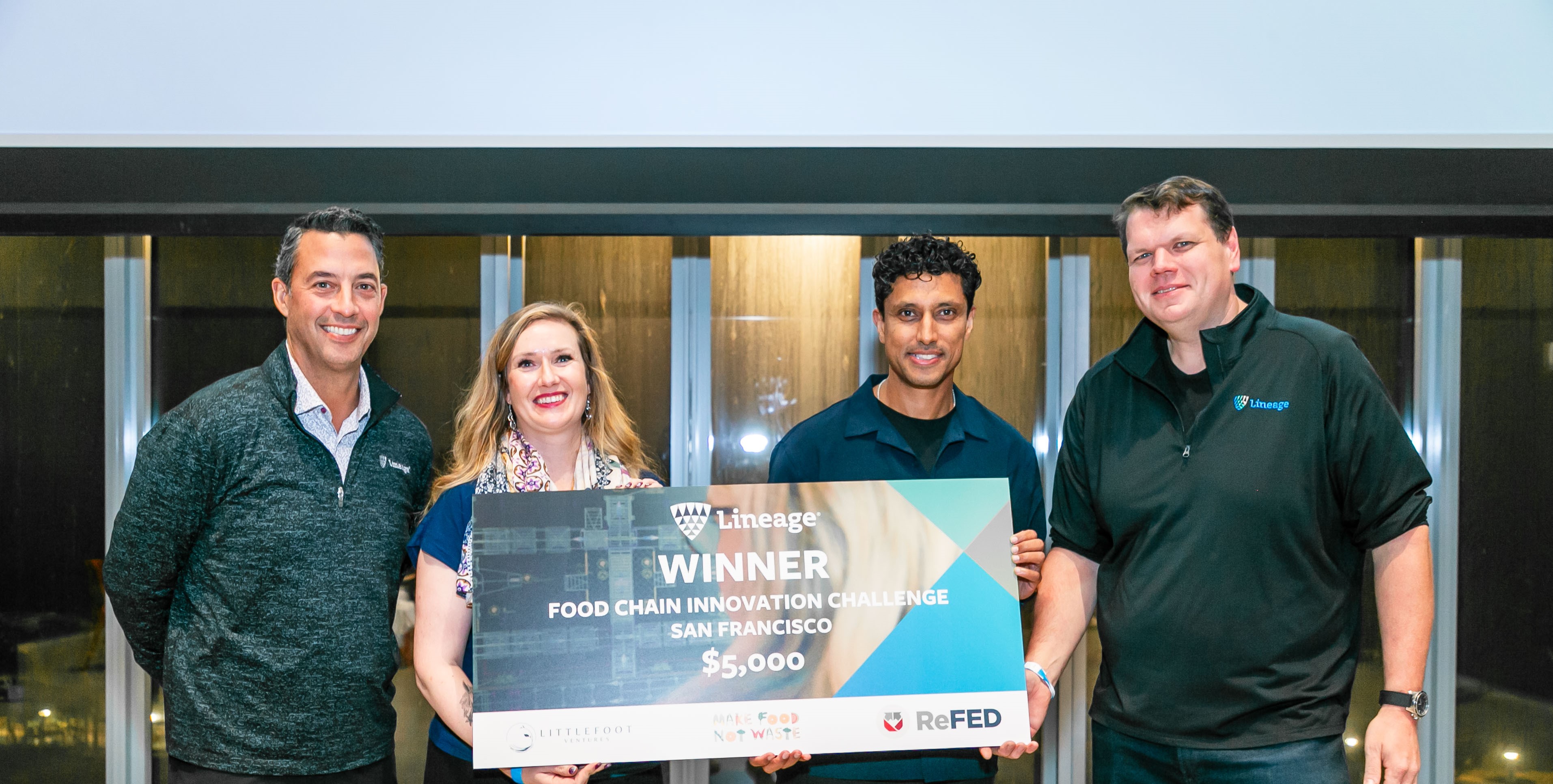 Los ganadores del Desafío de innovación en la cadena alimentaria de Lineage sostienen un gran cheque junto al Director de Operaciones y el Director Científico de Datos de la empresa.