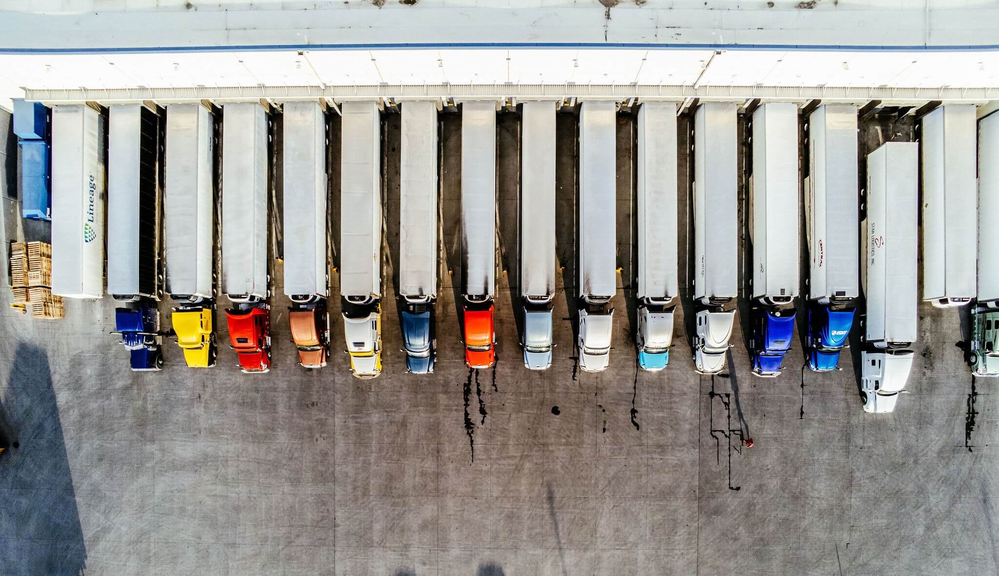 Aerial view of refrigerated trucks docked at a Lineage cold storage facility, ready for less-than-truckload shipping.
