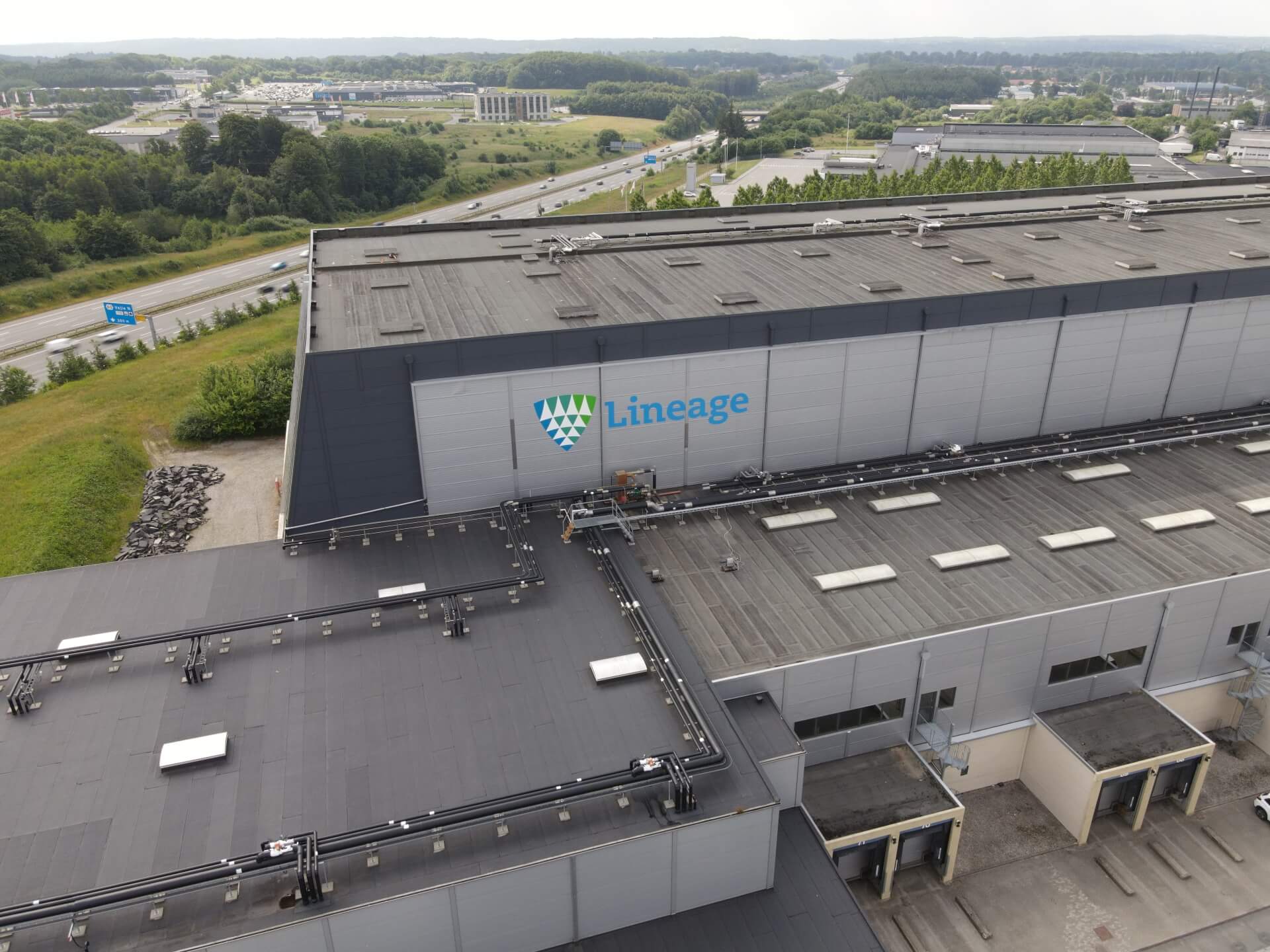 Vista aérea del almacén frigorífico de Lineageen Vejle, Dinamarca, que muestra los muelles de carga y la infraestructura circundante.