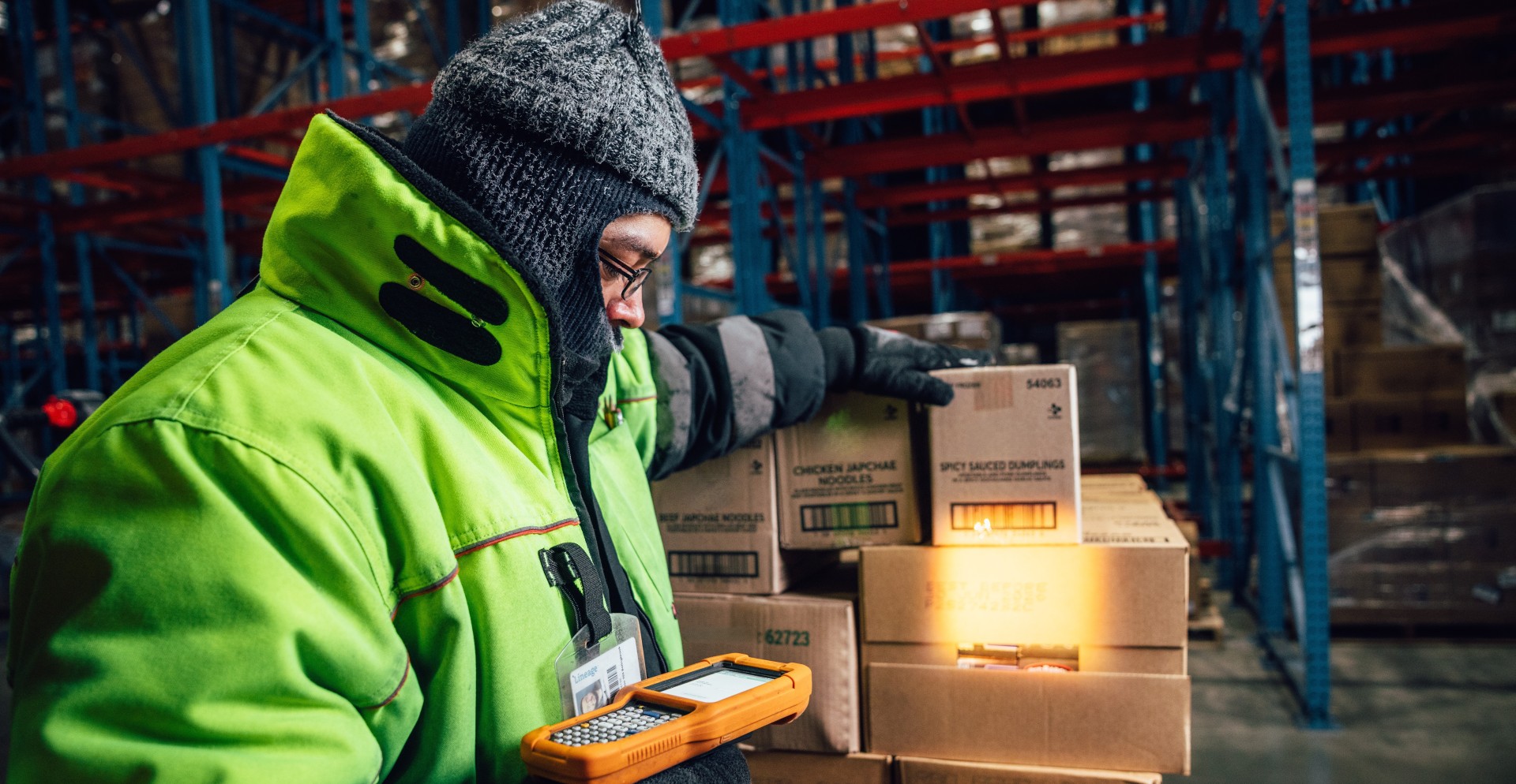 Lineage team member scans cases of food products inside a temperature-controlled warehouse to support inventory tracking and food traceability.