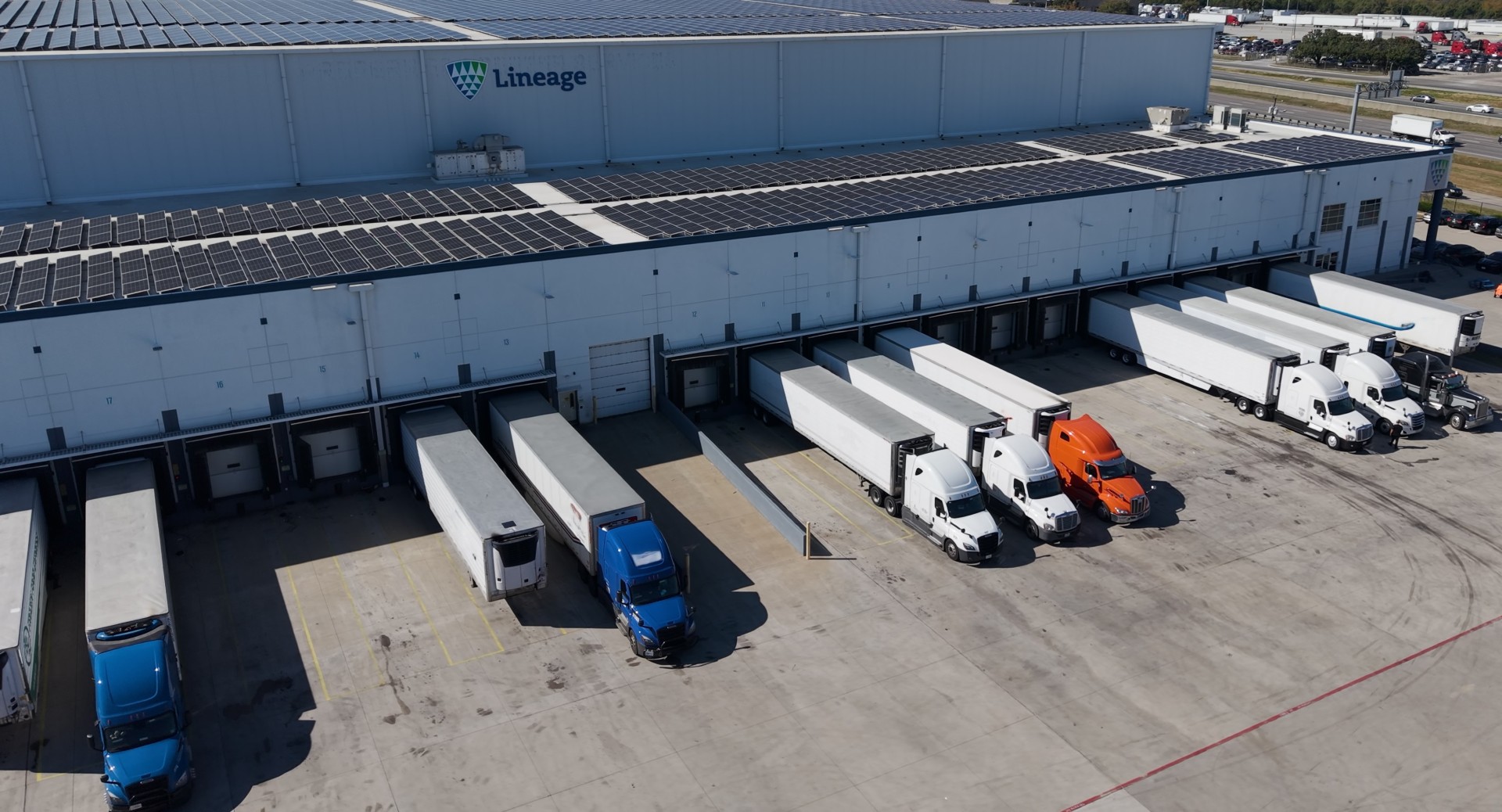 Aerial view of a Lineage cold storage facility with refrigerated trailers at loading docks, illustrating integrated cold chain operations, warehousing and transportation supporting food distribution.