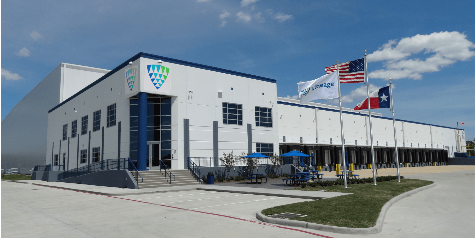 Lineage cold storage facility in Dallas-Fort Worth with loading docks and American and Texas flags outside the building.