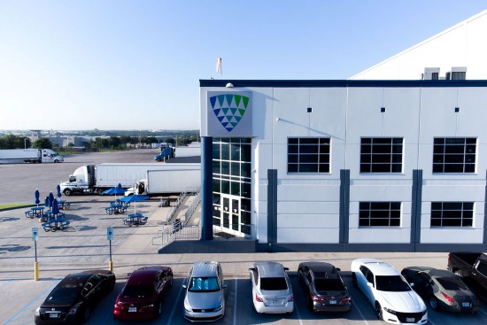 Lineage cold storage facility in Dallas-Fort Worth with trucks, outdoor seating and parked vehicles outside the warehouse.