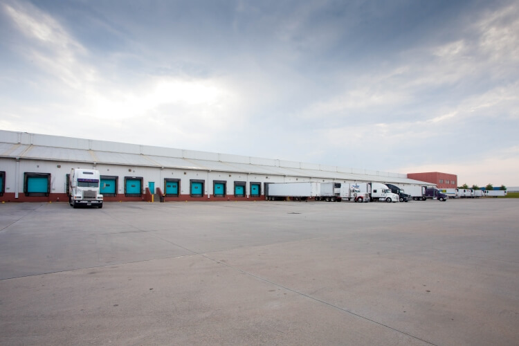 Vista desde el muelle del almacén frigorífico de Lineageen McDonough - 200 King Mill, con múltiples muelles de carga, semirremolques y un amplio patio de hormigón.