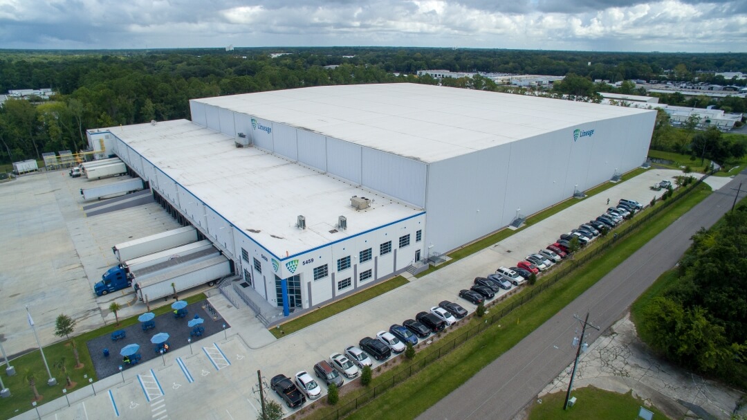 Vista aérea lateral de las instalaciones de Lineageen Doolittle, Jacksonville, que muestra un amplio espacio de almacén, muelles de carga y descarga y una zona de aparcamiento en buen estado.
