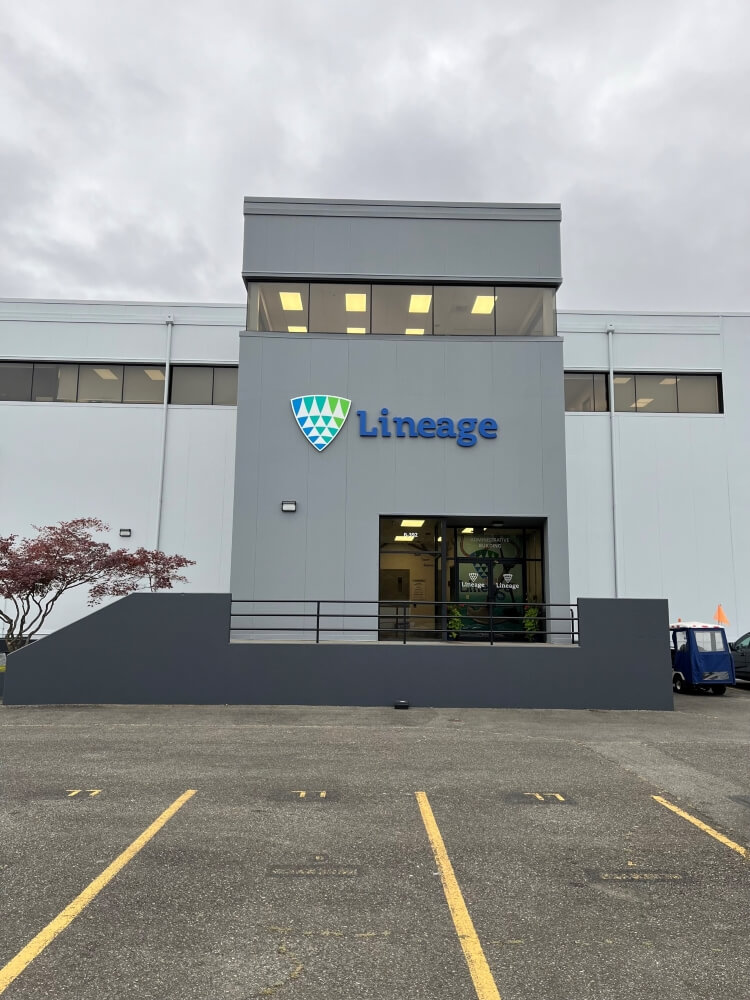 Entrée principale de Lineage Installation de Seattle-Garfield avec le logo de l’entreprise et une façade moderne bien éclairée sous un ciel nuageux.