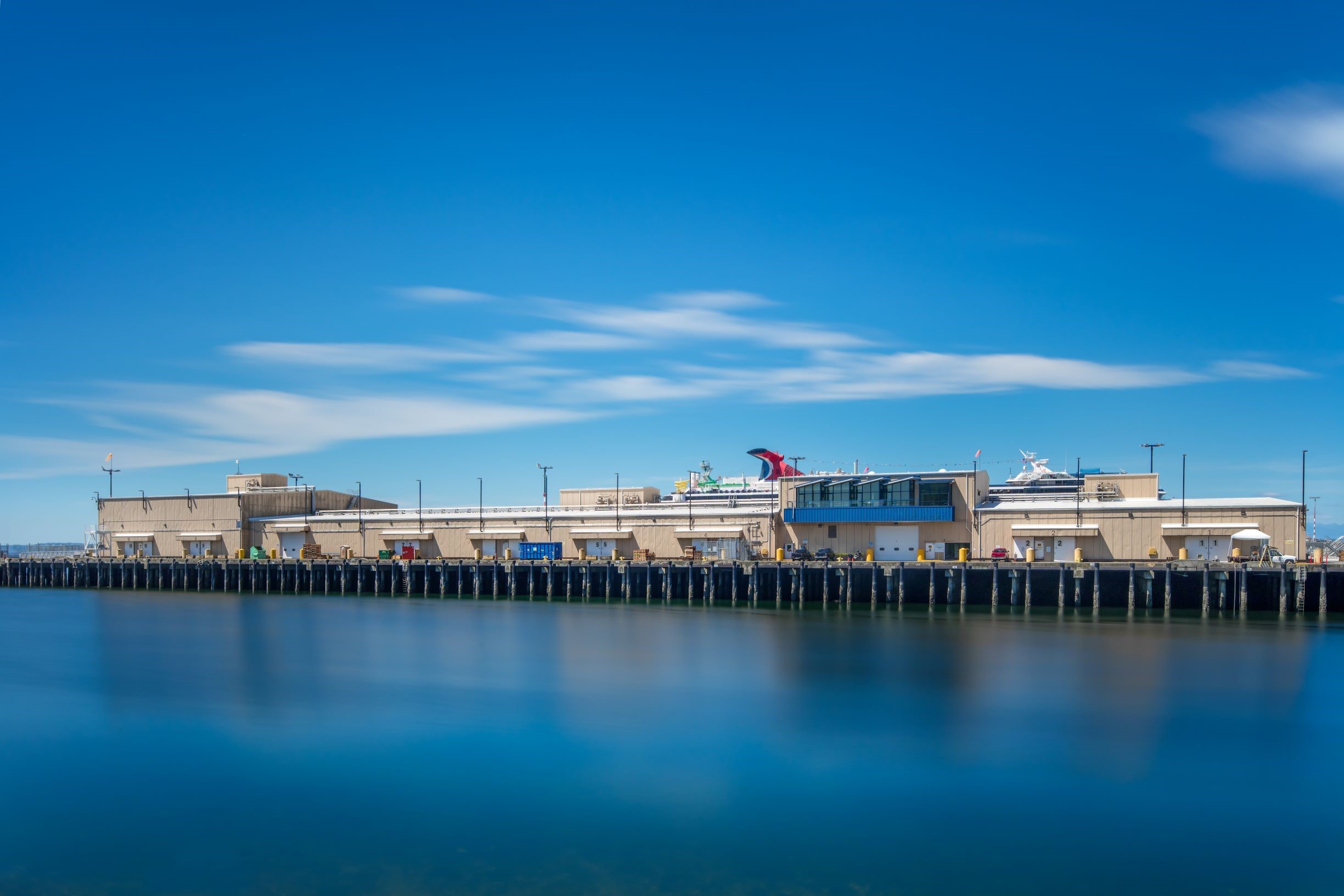 Vista gran angular de las instalaciones de Lineage Seattle-Garfield a lo largo del paseo marítimo bajo un cielo azul despejado, mostrando las operaciones e instalaciones portuarias.