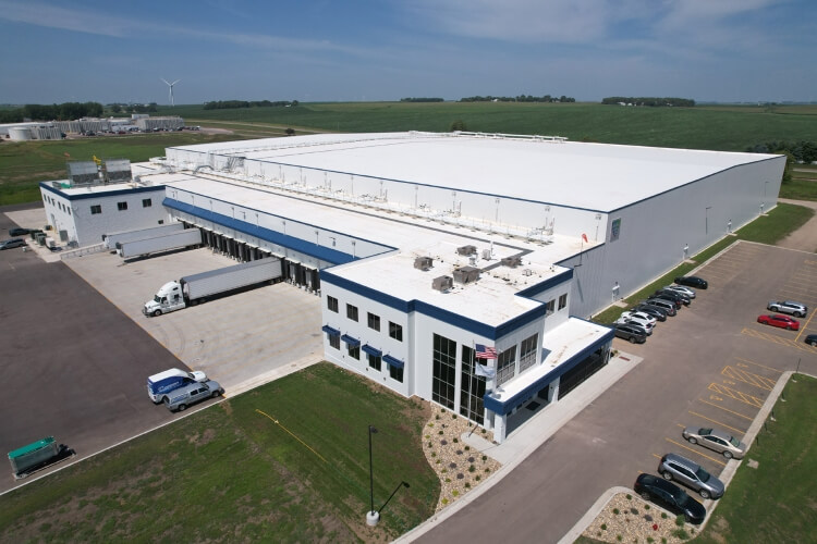 Vue aérienne de LineageL’entrepôt frigorifique de Luverne au Minnesota, doté d’une installation moderne avec plusieurs quais de chargement, des camions stationnés et des terres agricoles environnantes pour des opérations efficaces de la chaîne du froid.