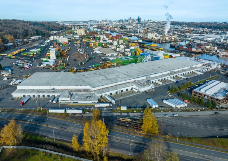 Amplia vista aérea de las instalaciones de Lineageen Seattle-Michigan con contenedores de transporte y el centro industrial de Seattle, mostrando la eficiente conectividad de la cadena de suministro.