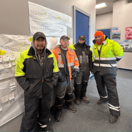 Lineage team members standing beside a process improvement board at a cold storage facility, highlighting collaborative Kaizen work to improve receiving and warehouse operations.