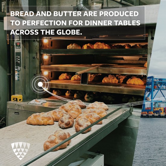 Fresh bread baking in a commercial oven with loaves on a conveyor, representing large-scale bakery production