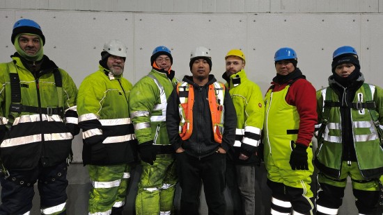 Miembros del equipo de almacenamiento frigorífico de Lineage Calgary Great Plains con equipos de alta visibilidad y cascos, juntos en el interior de las instalaciones.