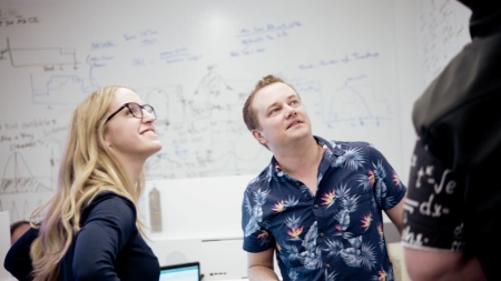 Lineage data science team members reviewing supply chain models and analytics on a whiteboard during a collaborative planning session.