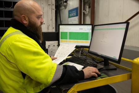 Lineage team member coordinating freight forwarding and cold chain logistics operations using real-time shipment tracking and transportation management systems.