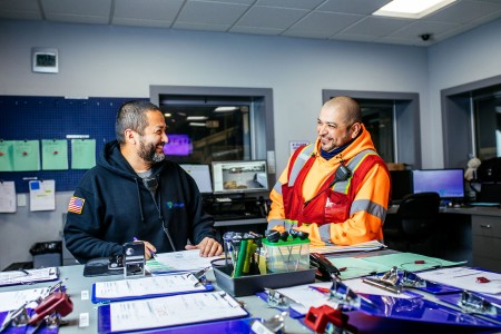 Two Lineage team members reviewing shipping and logistics documentation inside a cold chain operations office.