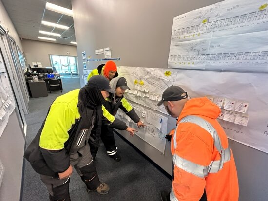 Lineage team members at the Dallas Dynasty facility review a detailed Value Stream Map on the wall during a Kaizen event to improve operational efficiency.