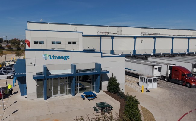 Exterior of the Lineage cold storage facility in Lancaster, Texas, with loading docks and refrigerated trucks.