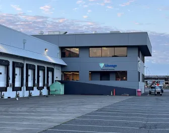 Instalaciones de Lineage Seattle-Garfield con una vista de los muelles de carga y el cartel de "Shipping & Receiving" bajo un cielo matutino.