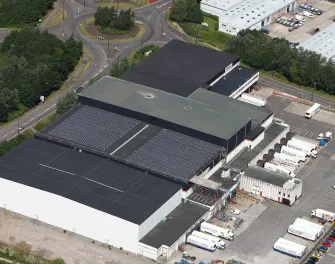 Vue aérienne de Lineagede Bristol à Portbury, au Royaume-Uni, avec des panneaux solaires sur le toit et des remorques sur le site.