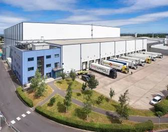 Vue aérienne de Lineageà Gloucester, au Royaume-Uni, montrant un vaste quai de chargement et un entrepôt entouré d’espaces résidentiels et verts