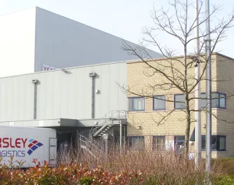 Vue de face de LineageHams Hall à Coleshill, au Royaume-Uni, avec un camion Yearsley Logistics et une enseigne Fire Assembly Point.