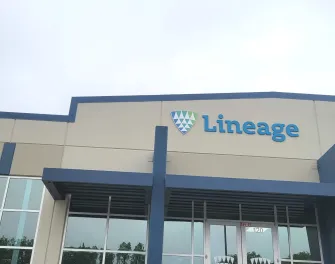 Front entrance of Lineage’s Lancaster, Texas facility, showing the blue-accented building facade, logo signage and glass entryway on an overcast day.