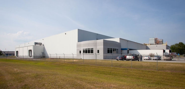 Exterior view of Lineage’s Macon cold storage facility in Atlanta, Georgia, featuring a white warehouse with loading docks, fenced perimeter, and a small office area.