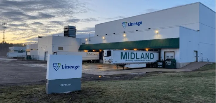 El almacén frigorífico de Lineage en Moncton, 123 Price Street, New Brunswick, con la señalización de la empresa, los muelles de carga y los remolques aparcados bajo el cielo de primera hora de la mañana.