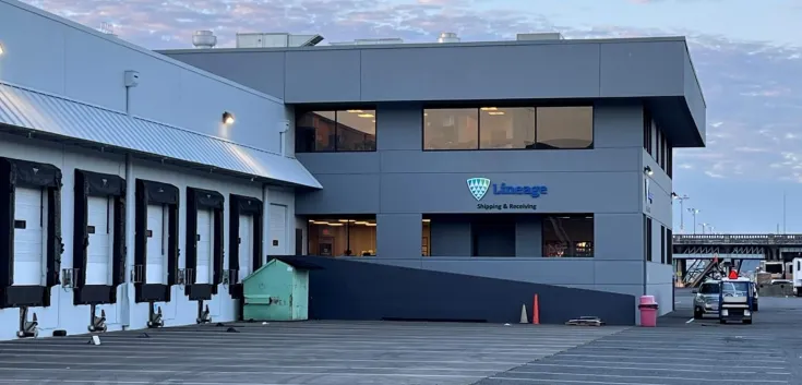 Instalaciones de Lineage Seattle-Garfield con una vista de los muelles de carga y el cartel de "Shipping & Receiving" bajo un cielo matutino.