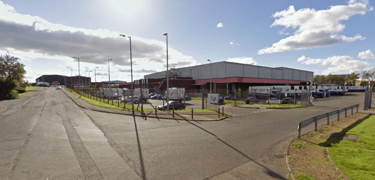 Street view of Lineage’s Bellshill cold storage facility in Scotland with Yearsley Group-branded trucks and secure gated access.