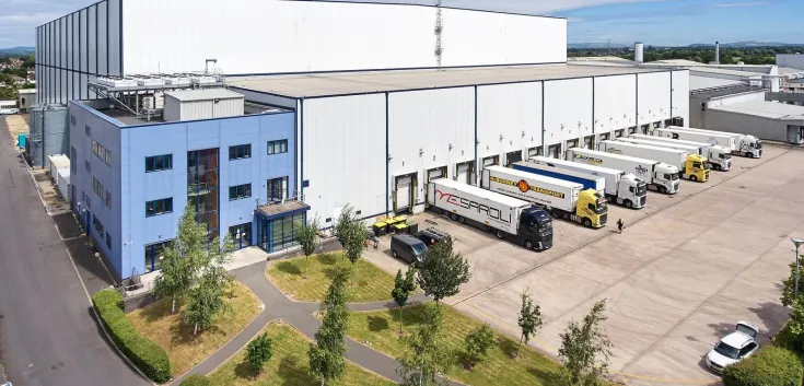 Vista aérea del almacén frigorífico de Lineageen Gloucester (Reino Unido), que muestra una amplia zona de muelles de carga y descarga y un almacén rodeado de zonas residenciales y verdes.