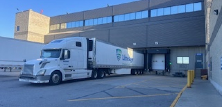 El almacén frigorífico de Lineage en Vaughan, Ontario, con un semirremolque blanco con la marca Lineage aparcado en un muelle de carga, apoyando las operaciones logísticas de la cadena de frío.