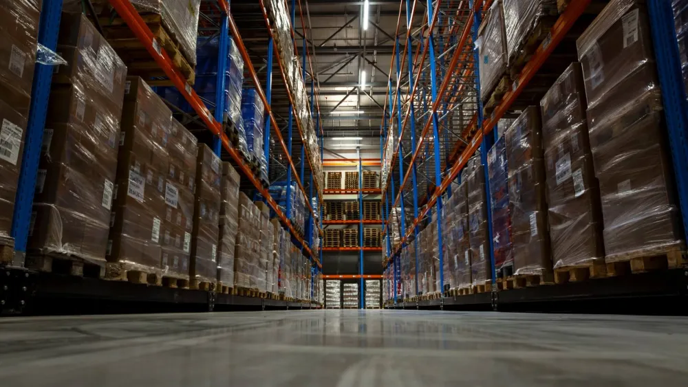 Rows of palletized products stored on high warehouse racks inside a temperature-controlled distribution facility, illustrating food inventory storage and traceability operations.
