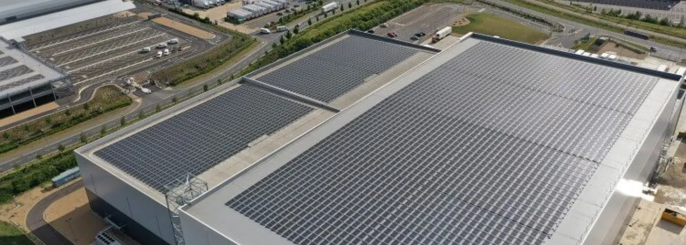 Almacén frigorífico de Lineageen Peterborough con paneles solares, muelles de carga y camiones de marca.