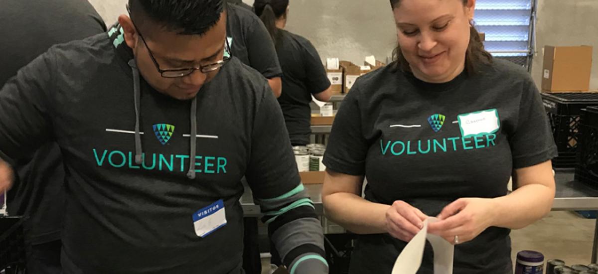 Two Lineage volunteers repacking canned goods