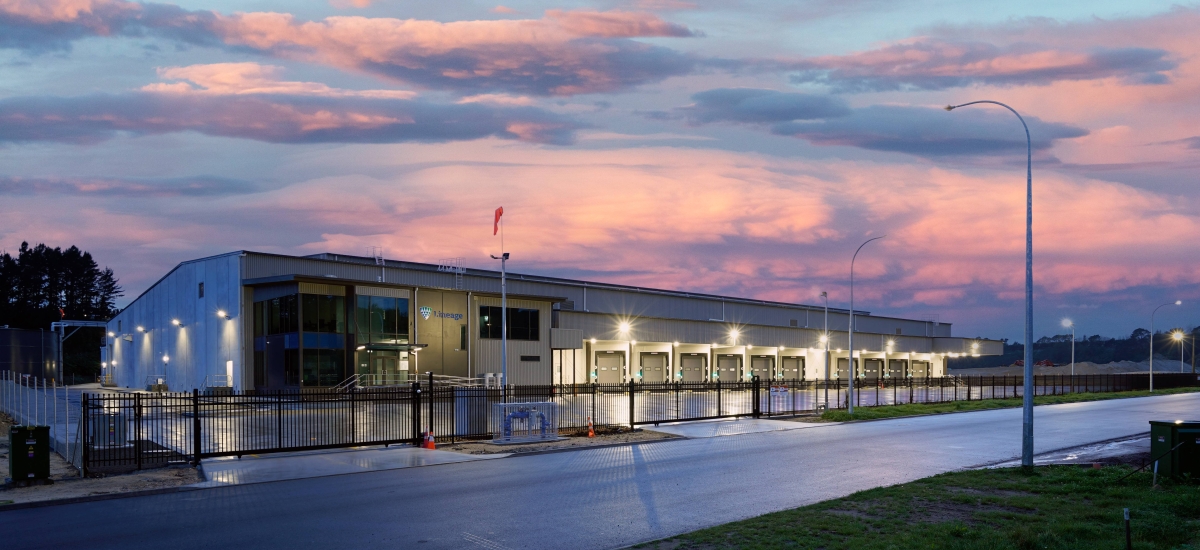 Lineage's newest temperature-controlled warehouse in Tauriko, Tauranga, New Zealand is illuminated against a spectacular sunrise. The sky is shades of pink, orange, purple and blue and provides a stunning backdrop for the new warehouse.