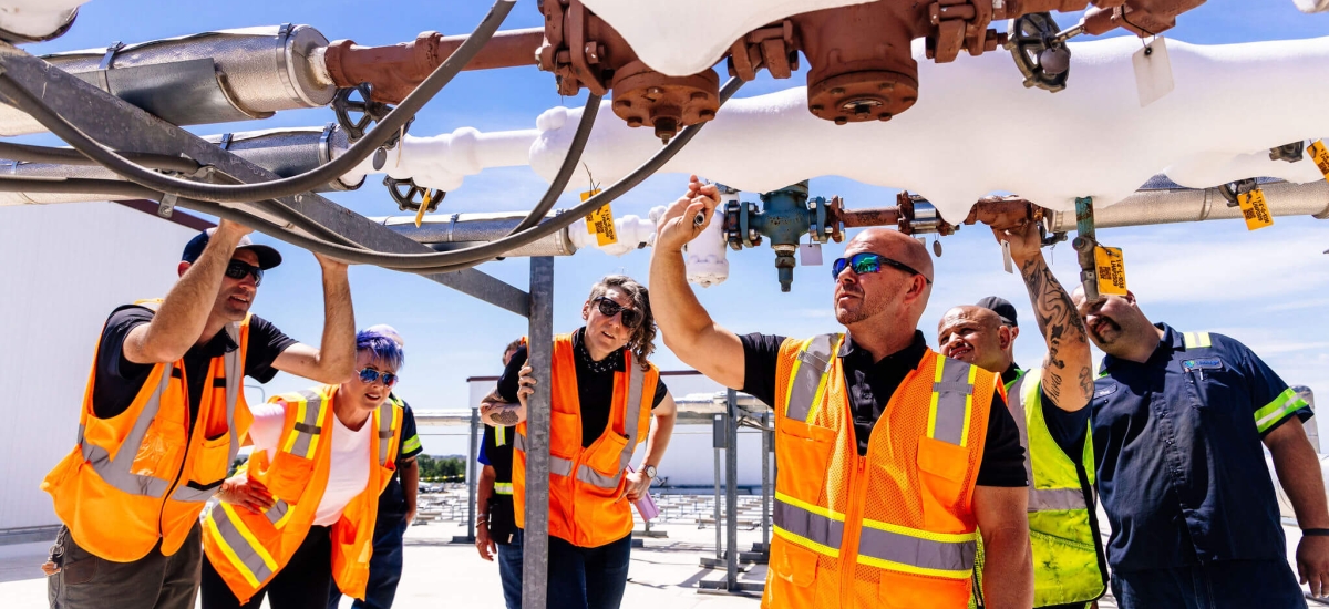 Team of Lineage team members engaged in a facility energy evaluation, inspecting and discussing equipment at Holmewood facility.