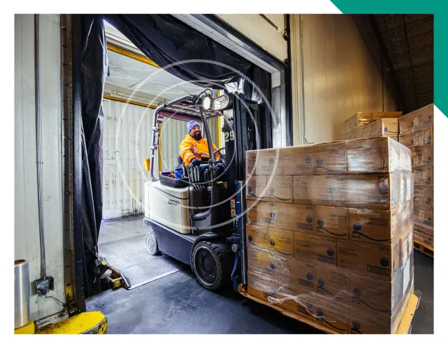 Lineage team member moving pallets of food in a cold storage warehouse in the Great Plains in the US.