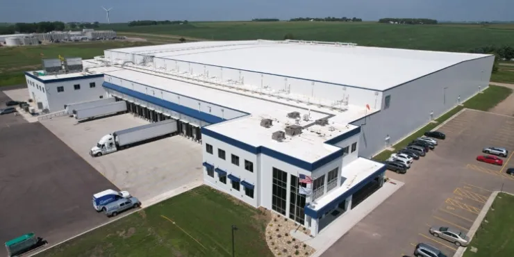 Vue aérienne de LineageL’entrepôt frigorifique de Luverne au Minnesota, doté d’une installation moderne avec plusieurs quais de chargement, des camions stationnés et des terres agricoles environnantes pour des opérations efficaces de la chaîne du froid.