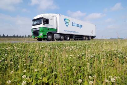 semi truck with the lineage logo on it driving on highway