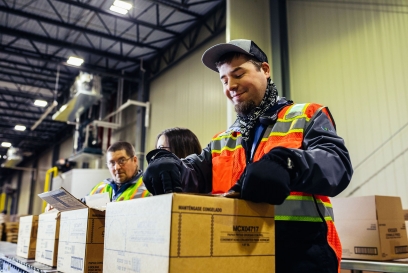 team members removing product out of boxes in the warehouse