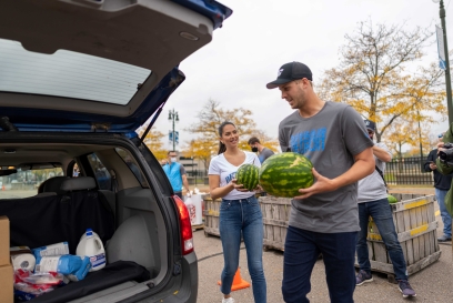 NFL Player Jared Goff holds fresh fruit as he loads a vehicle during a food donation event in Detroit