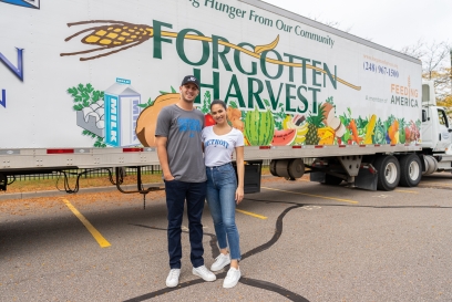 Detroit Lions quarterback Jared Goff and his fiancé, Christen Harper, stand in front of a Forgotten Harvest semi trailer at food donation event benefitting Detroiters