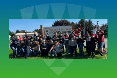A joyful group of Lineage team members posing outdoors at the Second Harvest Foodbank, celebrating their commitment to community service and team culture.